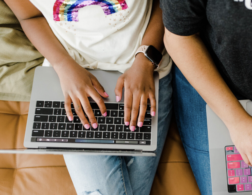 PERSON ON THEIR LAPTOP SITTING ON A COUCH